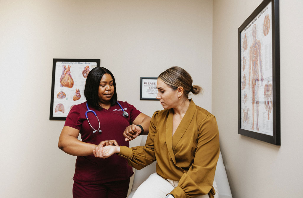 A cardiology healthcare professional is preparing to take a patient's blood pressure in a medical office setting.