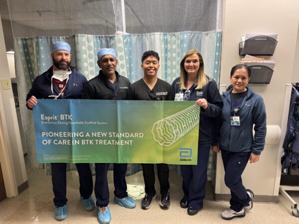 A group of medical professionals holding a banner promoting a new standard of care in BTK treatment.